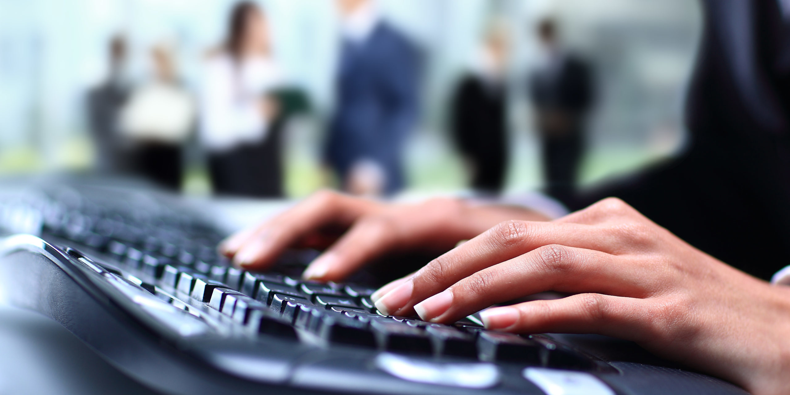 Human hands working on laptop on office background Bacteria are easily transferred on shared keyboards